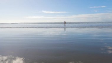 Küçük kız, soğuğa göğüs geriyor, kışın sahilde mayosuyla koşuyor..