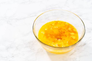 Islak malzemeleri büyük bir bardakta karıştırıp yumurta likörü pişirmek için karıştırıyorum..