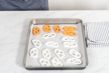 Çikolata soslu krakerlerin üzerine erimiş çikolata serpiştirmek..