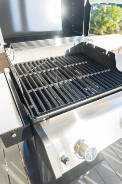 Gösterişli, açık kapaklı, çift ocaklı ızgara kullanıma hazır, banliyödeki bir evin balkonunda konumlandırılmış, nefis bir yemek pişirme deneyimi vaat ediyor..