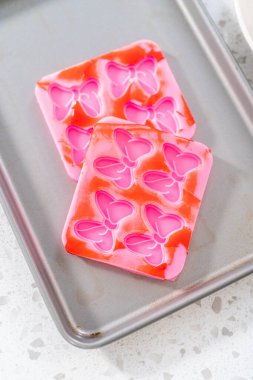 Removing chocolate bows from the silicone molds to make a chocolate pretzel Christmas wreath.