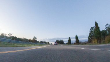 Güneş batarken, Pismo Sahili yakınlarındaki HWY 101 'de Kaliforniya turuncu ve pembeye boyanmış gökyüzü ile büyüleyici bir deneyim haline gelir ve kıyı manzarası üzerine sıcak bir parıltı yayar..