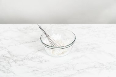 Küçük Paskalya ekmeği için limon jölesi yapmak için karışımı büyük bir karıştırıcı ile karıştırıyorum..