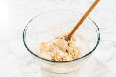 Büyük bir bardakta mayasız tarçınlı kek pişirmek için karışımı karıştırıyorum..