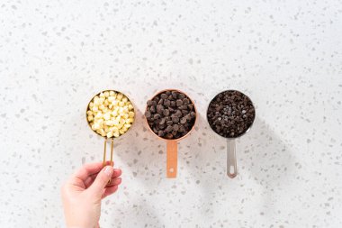 Düz yatıyordu. Metal ölçü bardaklarındaki çikolata parçacıklarının çeşitliliği.