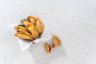 Düz yatıyordu. Mutfak tezgahındaki tavada taze pişmiş vişneli börek var..