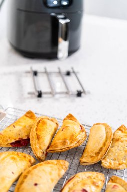 Mutfak tezgahındaki tavada taze pişmiş vişneli börek var..