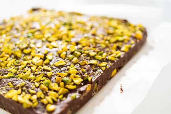 Scoring chocolate pistachio fudge into perfect squares for cutting.