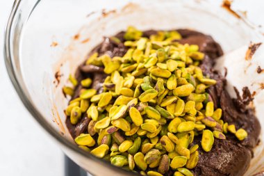 Melting white chocolate chips and other ingredients in the double boiler to prepare chocolate pistachio fudge.