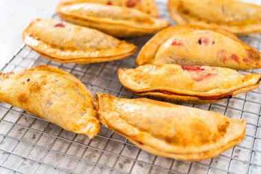 Mutfak tezgahındaki tavada taze pişmiş vişneli börek var..