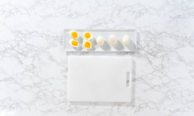 Beyaz bir kesme tahtasında haşlanmış yumurta dilimlemek..