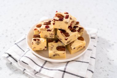 Beyaz seramik tabakta ev yapımı beyaz çikolatalı fındıklı şekerleme parçaları..