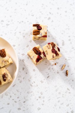 Manzarayı kapat. Mutfak tezgahında ev yapımı beyaz çikolatalı fındıklı çikolata parçaları var..