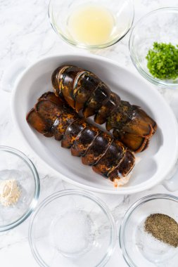 Düz yatıyordu. Sarımsaklı ıstakoz kuyruğu hazırlamak için cam karışımında ölçülmüş malzemeler..