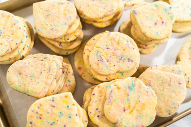 Büyük miktarda şekerli kurabiye düzgünce pişirme tepsisine istiflenmiş, paketlerinin kırsal kahverengi karton kutulara konmasını bekliyor..