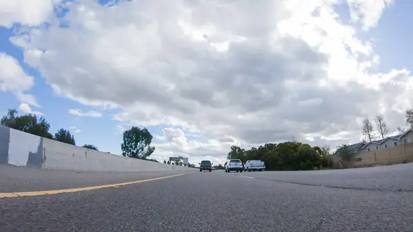 Santa Maria, California, ABD-6 Aralık 2022 - Bulutlu bir kış gününde, Santa Maria, California yakınlarındaki otoban boyunca bulutlu bir gökyüzünün altında, yeşil ve yeşil bir karışımla sorunsuz bir şekilde seyahat eden bir araba.