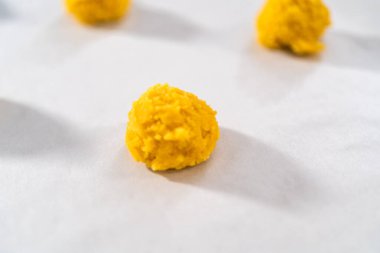 Beyaz çikolatalı limonlu kurabiye. Beyaz çikolatalı limonlu kurabiye pişirmek için parşömen kağıdıyla kaplı bir yemek tepsisine hamur kepçesiyle kurabiye pişirmek..