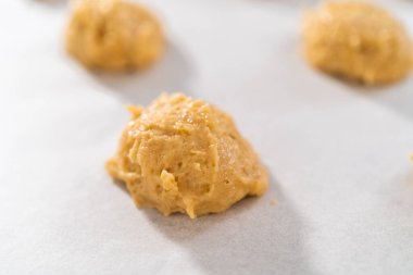 Kurabiye hamuru kepçesiyle kurabiye hamuru pişirip parşömen kağıdıyla kaplanmış bir tepsiye koyup muzlu kurabiyeleri çikolatalı çiselemek..