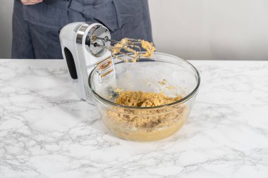 Mixing ingredients with a hand mixer to bake chocolate cookies with chocolate hearts for Valentines Day.