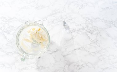 Düz yatıyordu. Amerikan bayrağı mini keklerini süslemek için tereyağlı kremayı poşetlere aktarıyorum..