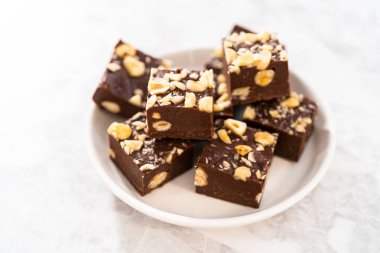 Beyaz tabakta ev yapımı çikolatalı fındıklı şekerleme parçaları..