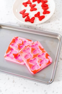 Removing chocolate bows from the silicone molds to make a chocolate pretzel Christmas wreath.