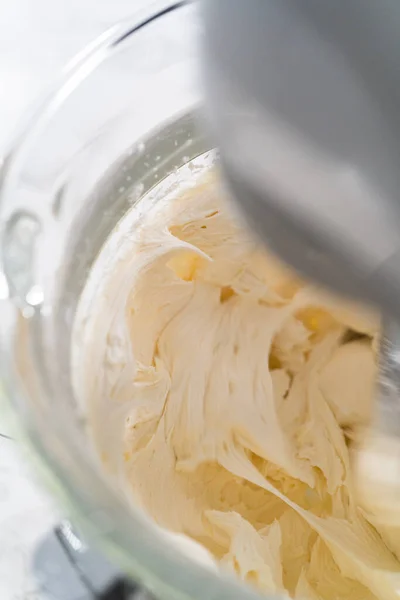 在厨房的电动搅拌器中混合配料 制成米黄色粉状奶油霜 — 图库照片