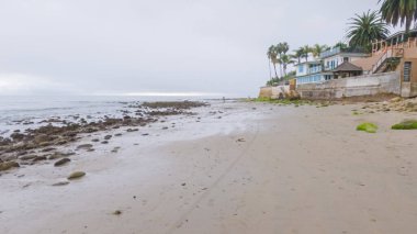 Kaliforniya, Miramar Sahili kıyılarında yürürken bulutlu kış gökyüzü sakin ve yansıtıcı bir atmosfer yaratır..