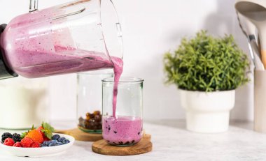 Taze yapılmış meyveli buzlu içeceği bardağa dolduruyorum..