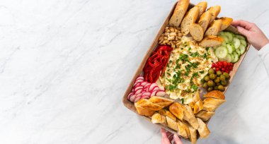 Düz yatıyordu. Büyük bir vejetaryen parti tereyağı tahtası. Parti için taze sebze turşusu ve dilimlenmiş Fransız ekmeği..