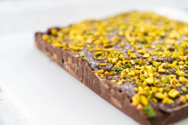 Scoring chocolate pistachio fudge into perfect squares for cutting.