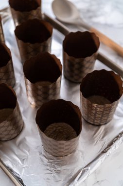 Paskalya ekmeği pişirmek için ekmek hamurunu kağıt kalemin içine karıştırmak..