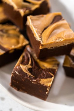 Fıstık ezmeli ve beyaz servis tabağında bulunan ev yapımı çikolatalı şekerleme..