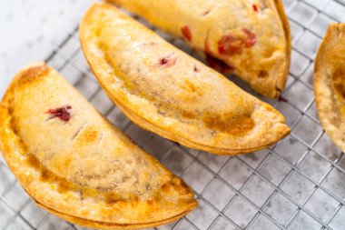 Mutfak tezgahındaki tavada taze pişmiş vişneli börek var..