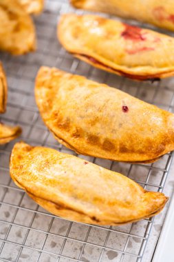 Mutfak tezgahındaki tavada taze pişmiş vişneli börek var..