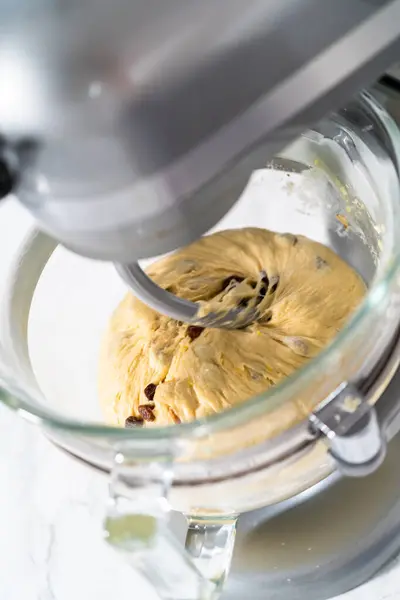 Mixing ingredients in kitchen mixer to bake mini Easter bread kulich.