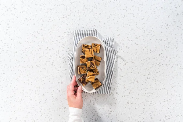 Plat Gelegd Zelfgemaakte Chocolade Fudge Met Pindakaas Wervelstukken Een Witte — Stockfoto