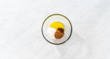 Flat lay. Mixing wet ingredients in a small glass mixing bowl to bake gingerbread bundt cake with caramel filling.