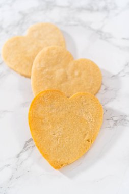 Sevgililer Günü için pembe ve beyaz kraliyet kremalı kalp şeklinde kurabiyeler..