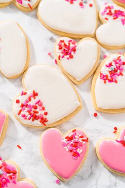 Sevgililer Günü için pembe ve beyaz kraliyet kremalı kalp şeklinde kurabiyeler..