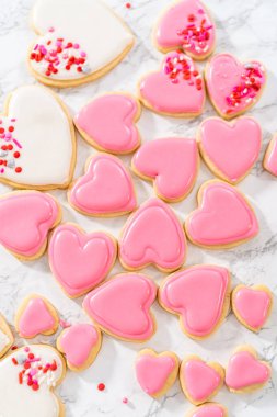 Sevgililer Günü için pembe ve beyaz kraliyet kremalı kalp şeklinde kurabiyeler..