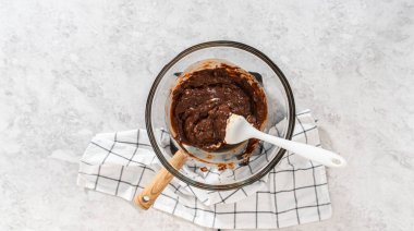 Düz yatıyordu. Eriyen beyaz çikolata parçaları ve diğer malzemeler kaynamış suyun üzerine karıştırıp çubuk şekerleme hazırlıyor..