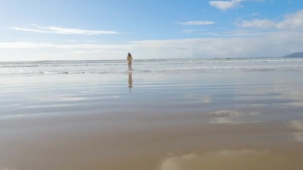 小女孩不顾严寒 穿着泳衣高高兴兴地跑过海滩 — 图库视频影像