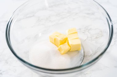 Mini vanilyalı kekler ve ombre pembe kremalı krema pişirmek için büyük bir karıştırma kabında malzemeler karıştırılıyor..