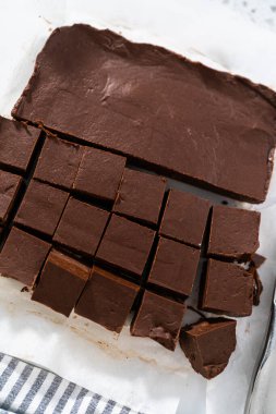 Beyaz bir kesme tahtasıyla ev yapımı şekerlemeleri küçük parçalara ayırmak..