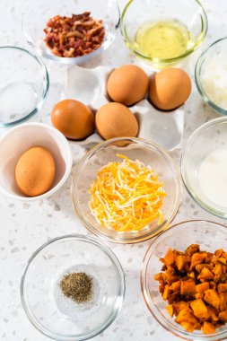 Kahvaltıda yumurta ve tatlı patatesle börek yapmak için cam kaselerde ölçülmüş malzemeler..