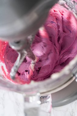 Mutfaktaki elektrikli mikserin içeriğini karıştırıp tereyağlı krema yapıyorum..