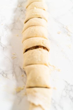 Tarçın ile doldurulmuş rulo ekmek hamuru ve daha küçük rulolara doğranmış fındıklar tarçınsız kek pişirmek için..