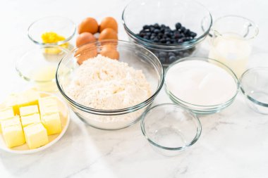 Limonlu yaban mersinli kek pişirmek için bardakların içindeki ölçülü malzemeler..