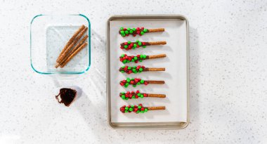 Denver, Colorado, ABD-18 Aralık 2022-Flat lay. Çubuk krakerleri erimiş çikolataya batırmak ve çikolata kaplı çubuk çubuklar yapmak için şeker serpmek..